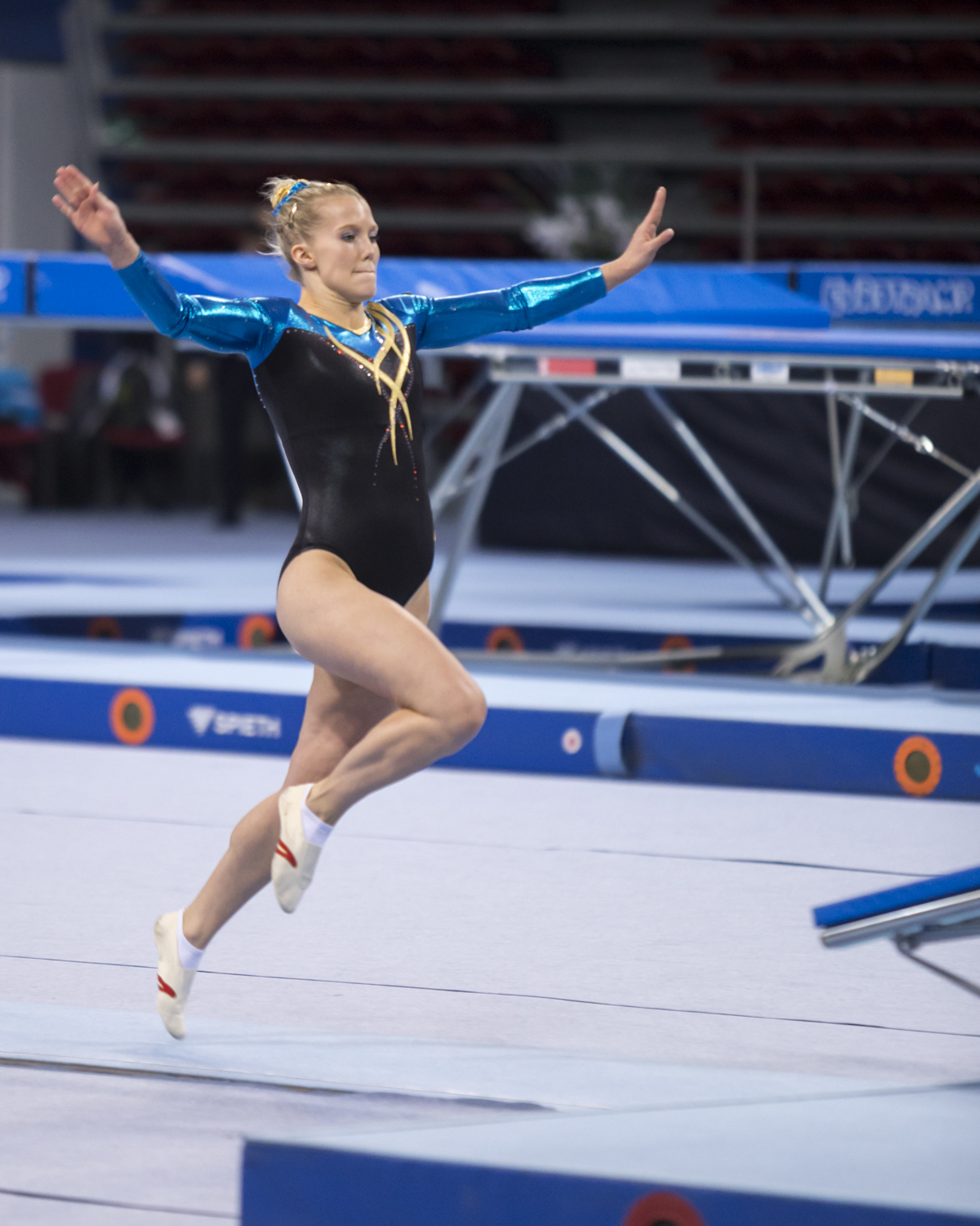 Photographie couleur de la Suédoise Lina Sjoeberg, double championne du monde de Double Mini Trampoline, en pleine course d'élan avant son passage lors de la finale individuelle