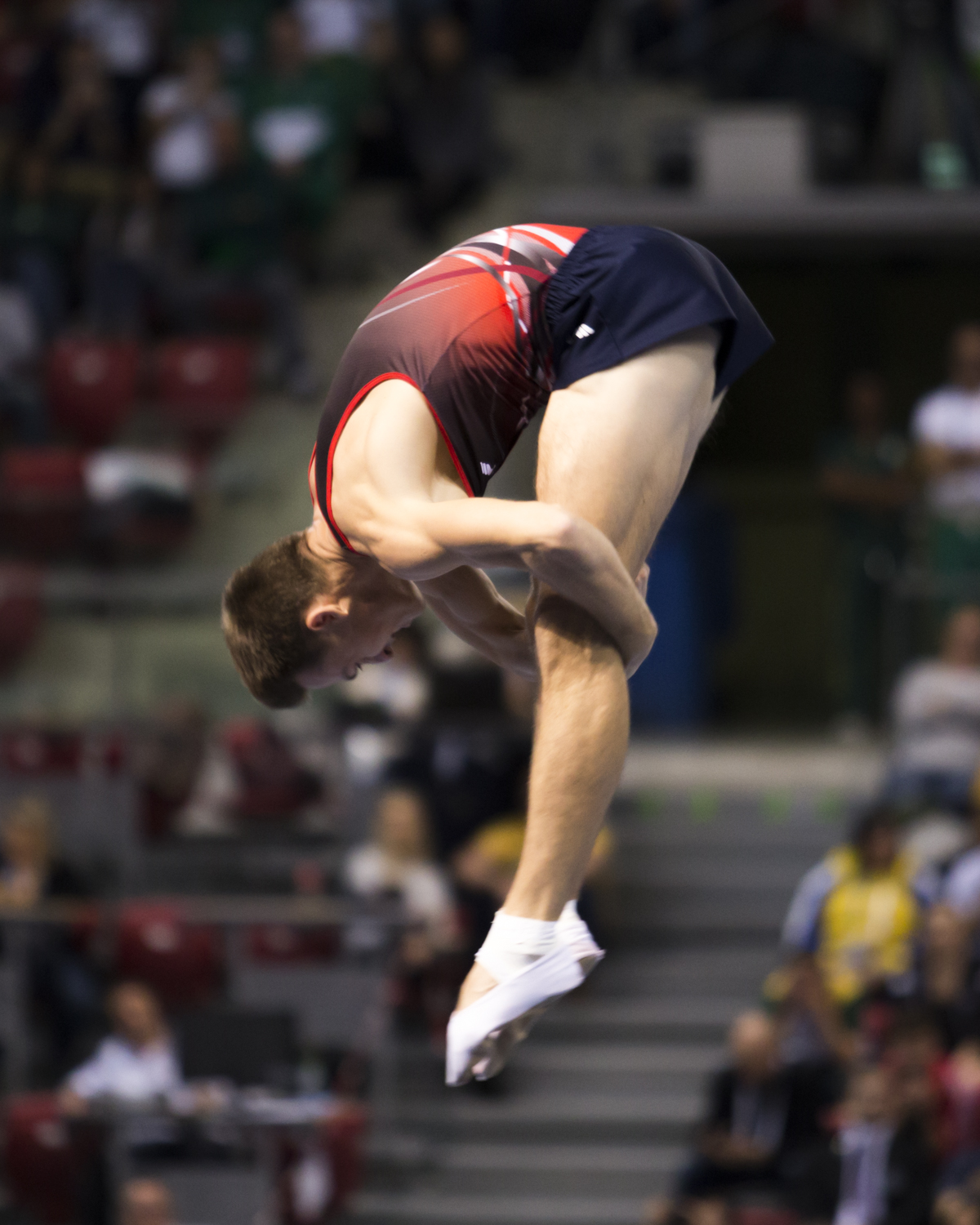 Photographie couleur du russe Dmitrii Ushakov en position de salto carpé lors de son passage en Trampoline individuel