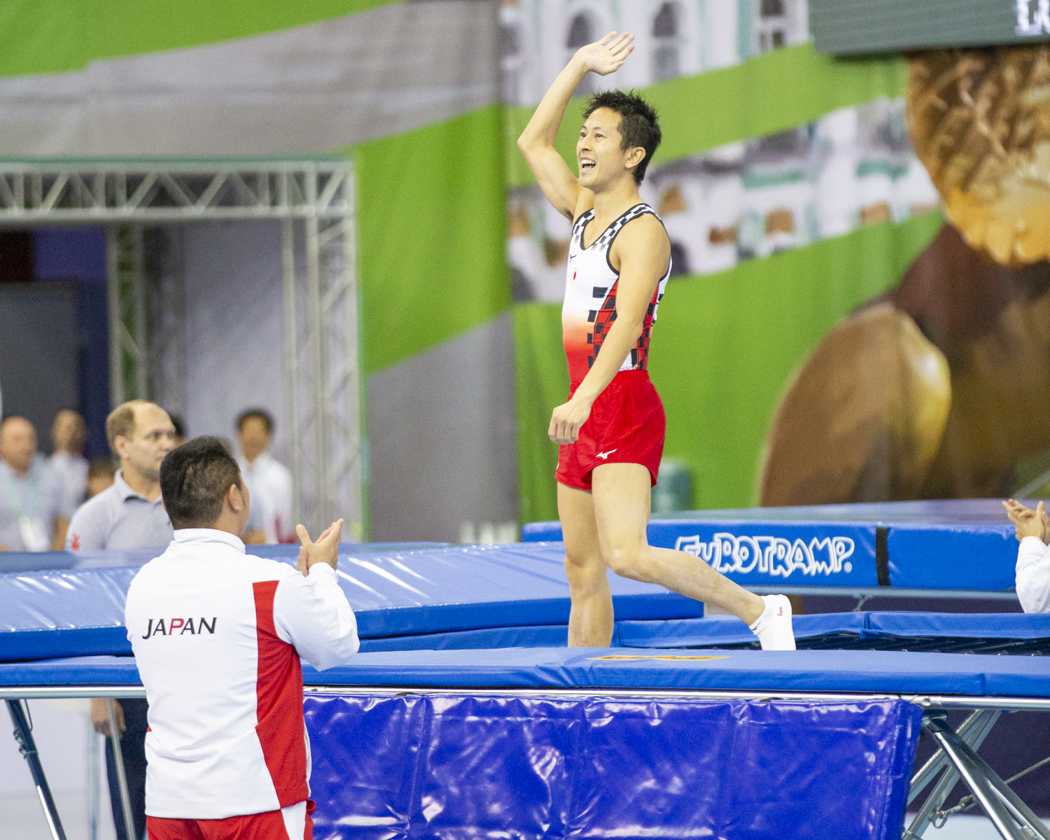 Photographie couleur de Tetsuya Sotomura, du Japon, levant les bras de joie après la réussite de son passage au Trampoline