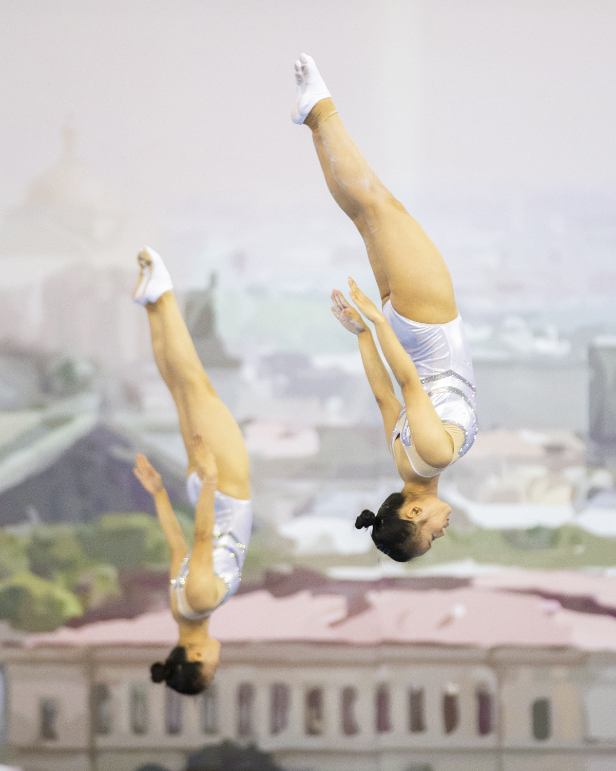 Photographie couleur de l'équipe de la République Populaire de Chine en Trampoline Synchronisé avec Zhong Xingping et Liu Lingling en position de salto tendue