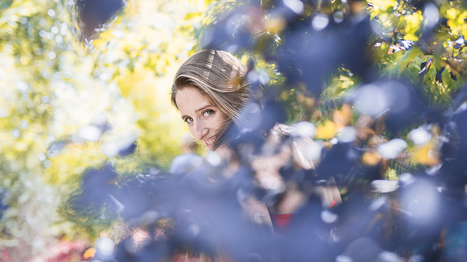 Photographie couleur de Cécile Reiter encadrée par de nombreuses fleurs