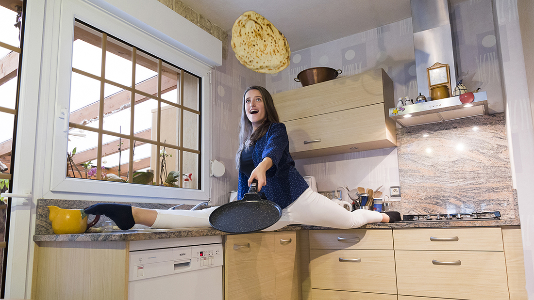 Photographie couleur avec la mise en scène humoristique d'une danseuse saisant sauter des crêpes