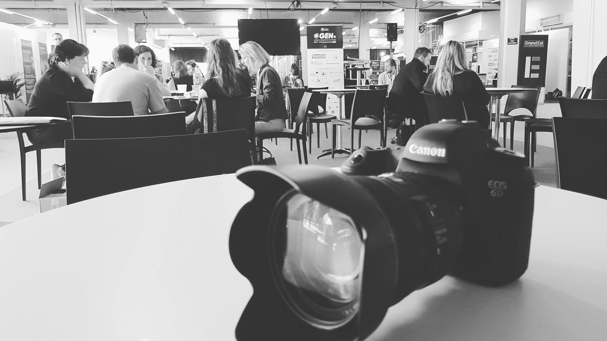 Photographie en noir et blanc d'un appareil photo posé sur la table lors d'un evenement professionnel