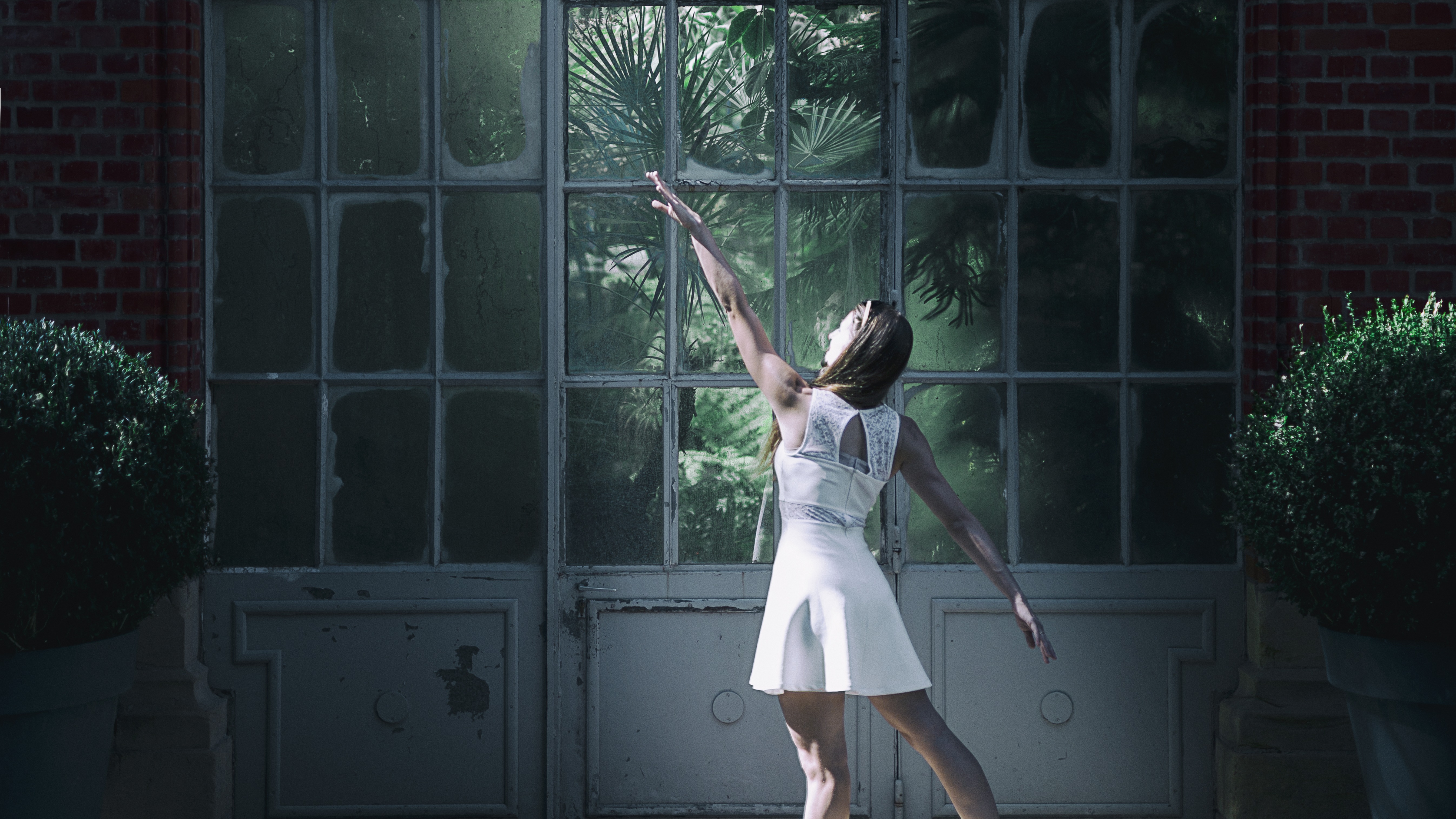 Photographie couleur avec la mise en scène d'une danseuse devant une serre