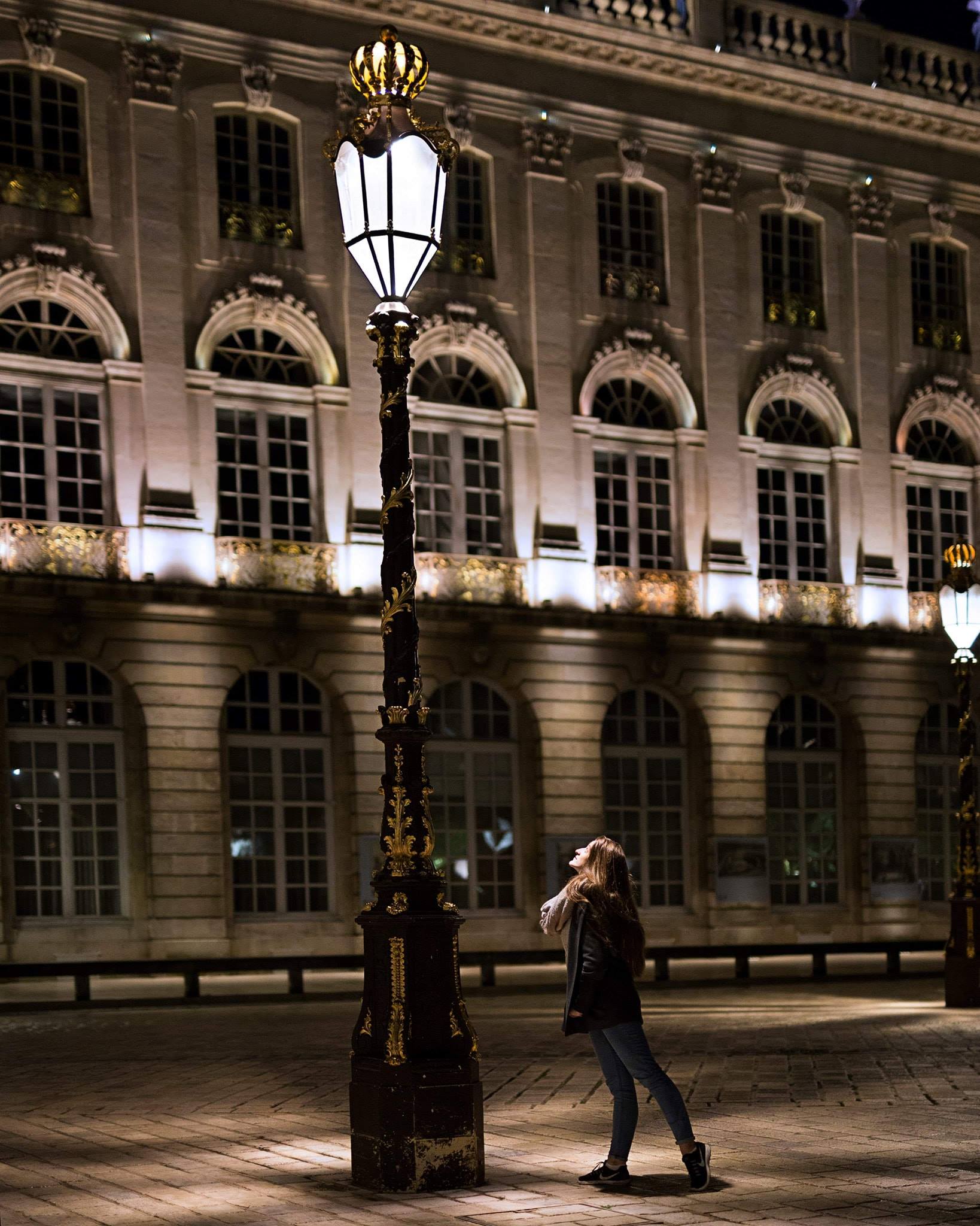 Photographie couleur avec la mise en scène d'une danseuse dans la nuit, sur la place Stanislas de Nancy en France